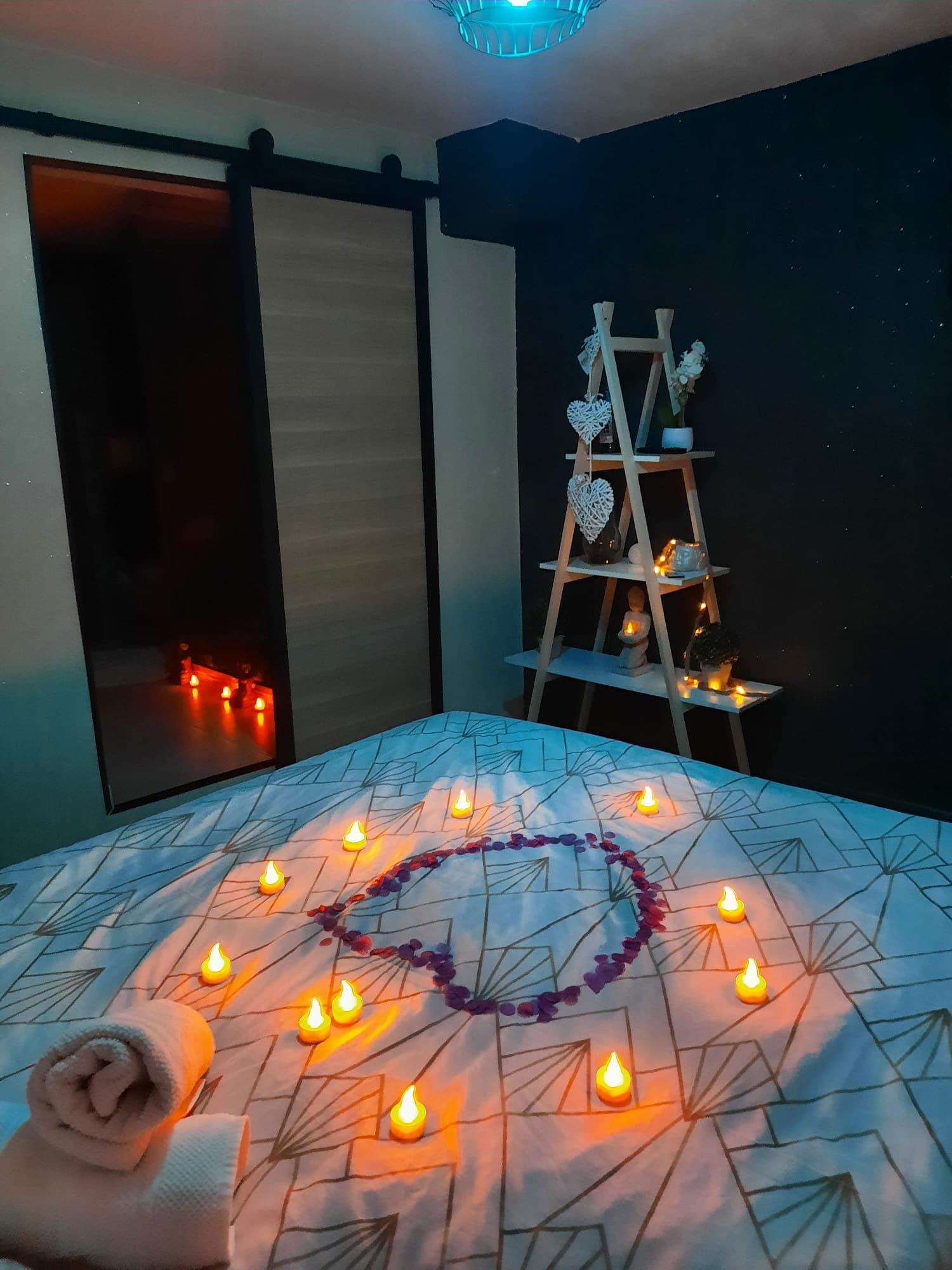 Lit préparé avec lumières douces et décor romantique dans la love room