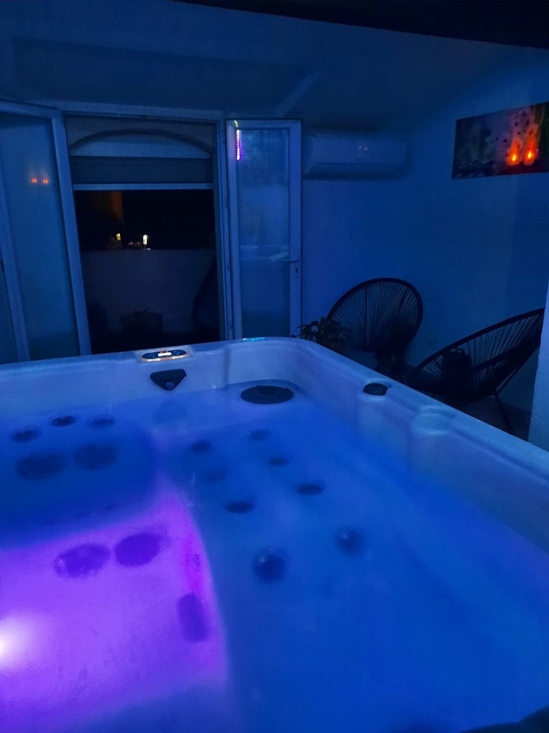 Jacuzzi privatif avec lumière bleutée dans la love room