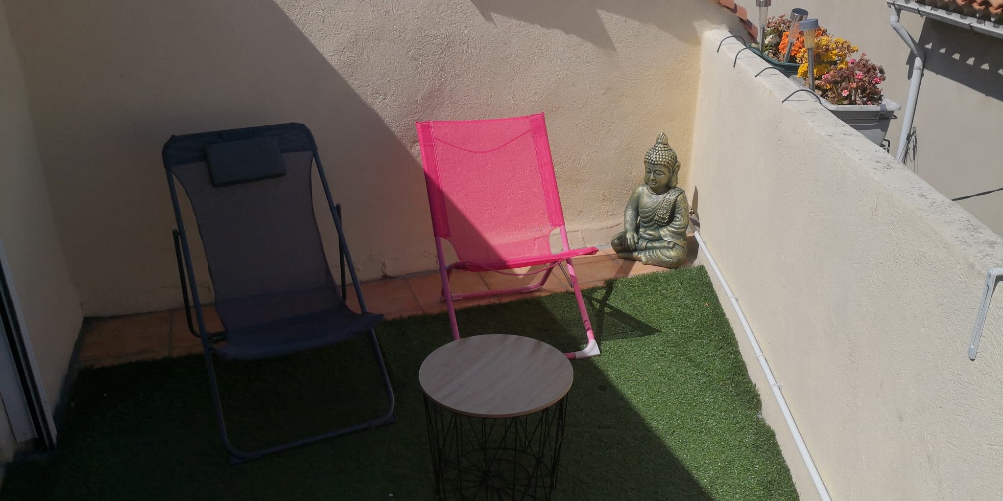 Terrasse avec fauteuils colorés et vue sur les toits du village