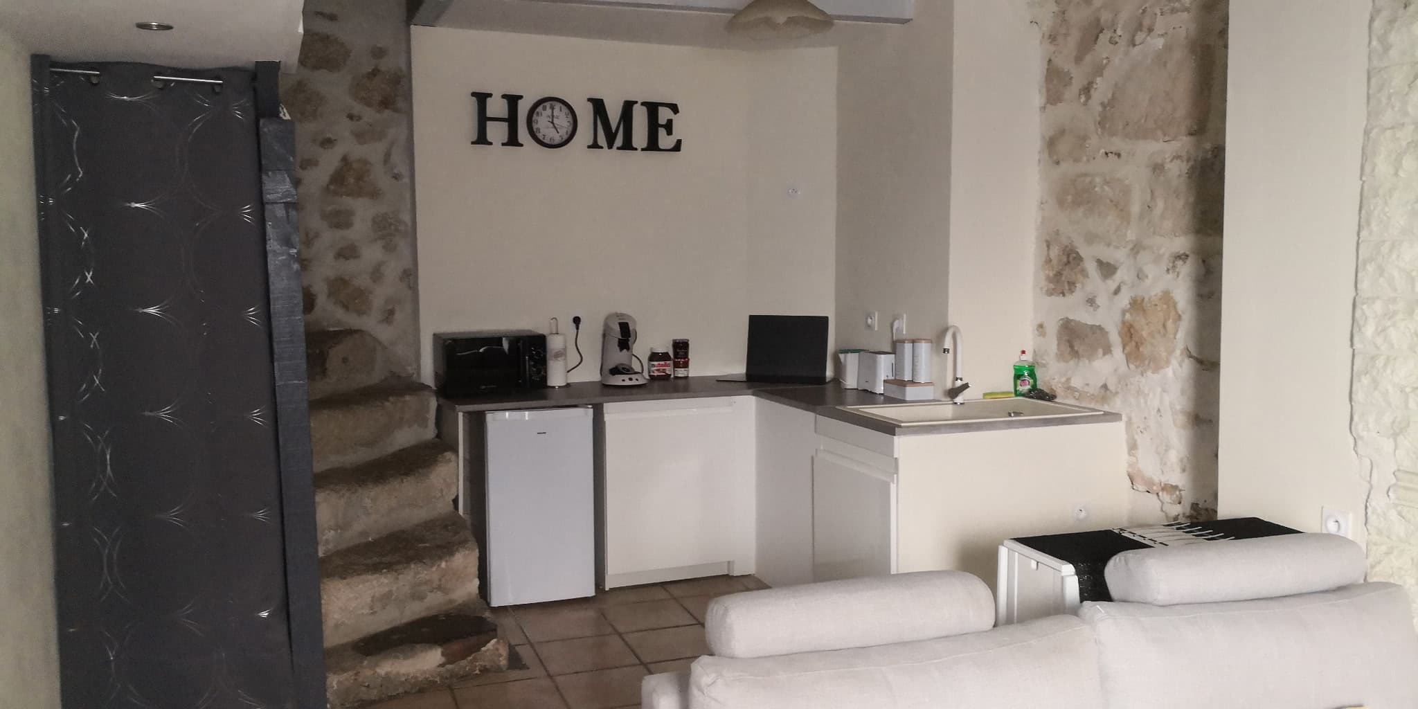 Salon de la suite avec coin repas et murs en pierre à Saint-Mitre-les-Remparts